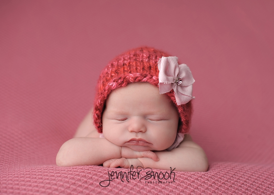 newborn baby propped up on chin